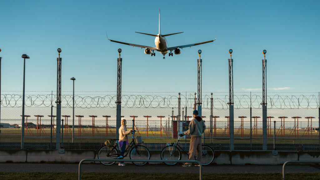 ein flugzeug fliegt über einen Zaun