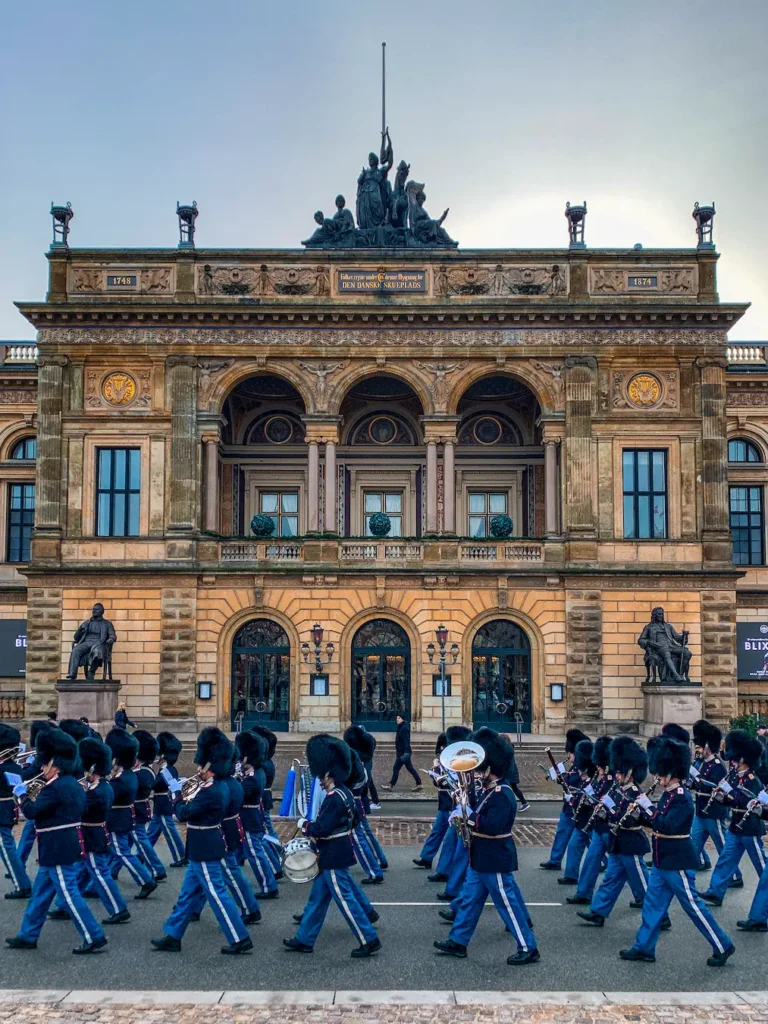 Menschen in Uniform vor einem historischen Gebäude.